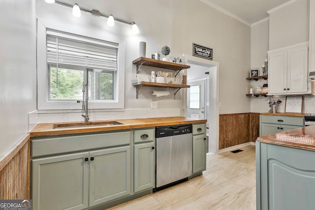 kitchen featuring dishwasher, crown molding, wood counters, and sink