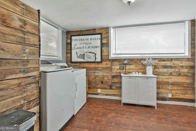 laundry room featuring wood walls, dark hardwood / wood-style floors, and washer and dryer