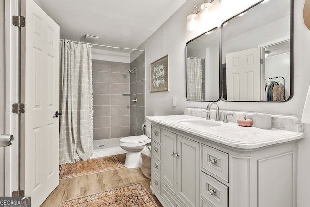 bathroom featuring walk in shower, toilet, vanity, and hardwood / wood-style floors