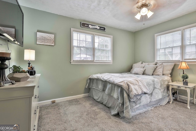 bedroom featuring ceiling fan, light colored carpet, and multiple windows