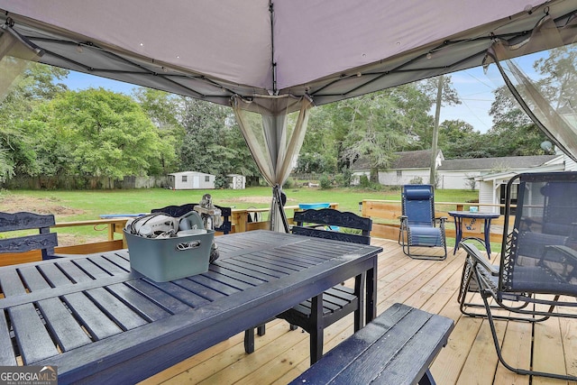 wooden deck featuring a lawn and a storage shed