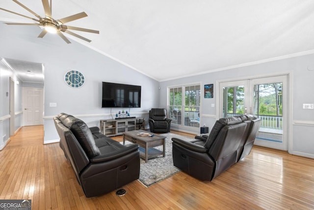 living room with light hardwood / wood-style floors, ornamental molding, and vaulted ceiling