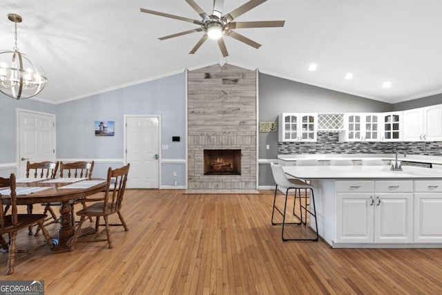 1011 Sugar Hill Way, Buckhead, GA 30625 - kitchen with a large fireplace, light countertops, white cabinets, light wood finished floors, and glass insert cabinets