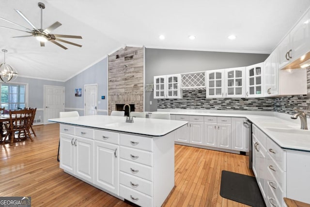 kitchen featuring a center island, light hardwood / wood-style flooring, white cabinetry, and lofted ceiling