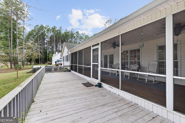 deck with ceiling fan, a lawn, and a sunroom