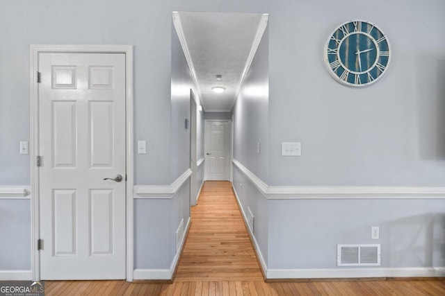 hallway featuring wood-type flooring and crown molding