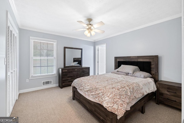 carpeted bedroom featuring a closet, ceiling fan, and ornamental molding