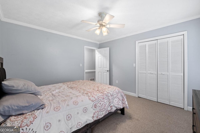 carpeted bedroom with ceiling fan, crown molding, and a closet