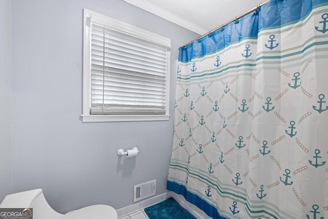 bathroom with tile patterned floors, crown molding, shower / tub combo with curtain, and toilet