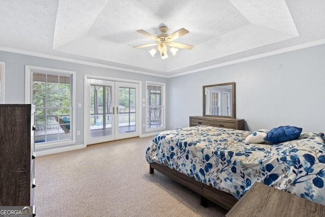 carpeted bedroom featuring a tray ceiling, access to exterior, ceiling fan, and french doors