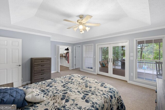 bedroom featuring access to outside, a raised ceiling, ceiling fan, and light colored carpet