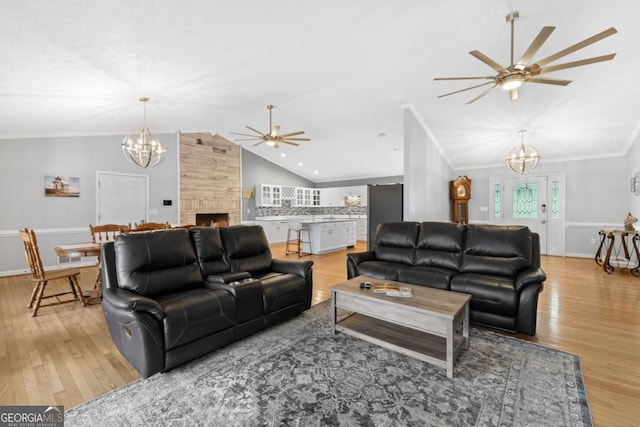 1011 Sugar Hill Way, Buckhead, GA 30625 - living room with a ceiling fan, a chandelier, vaulted ceiling, light wood-style floors, and a fireplace