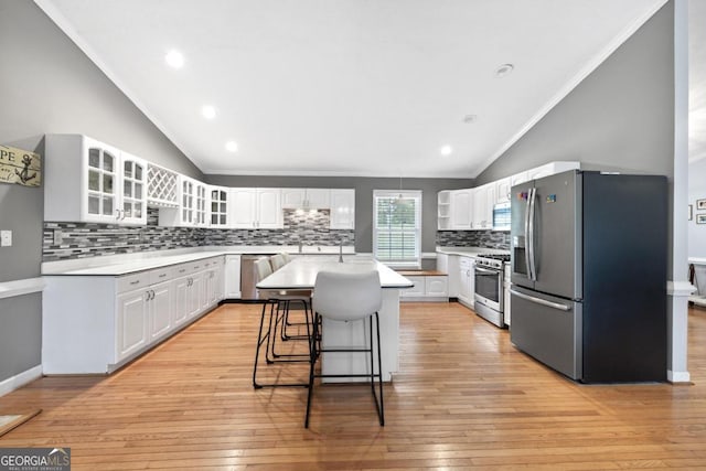 1011 Sugar Hill Way, Buckhead, GA 30625 - kitchen with stainless steel appliances, vaulted ceiling, decorative backsplash, a center island, and white cabinets