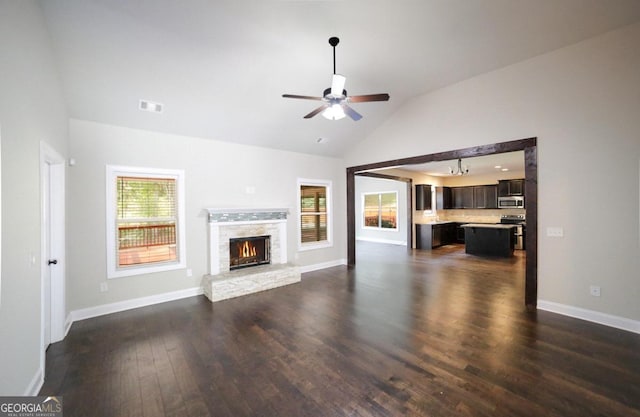 unfurnished living room with vaulted ceiling, dark hardwood / wood-style floors, and ceiling fan