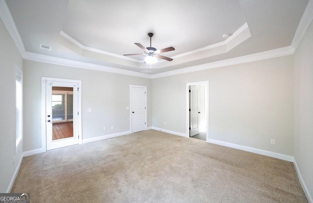 spare room with ornamental molding, a tray ceiling, ceiling fan, and light carpet