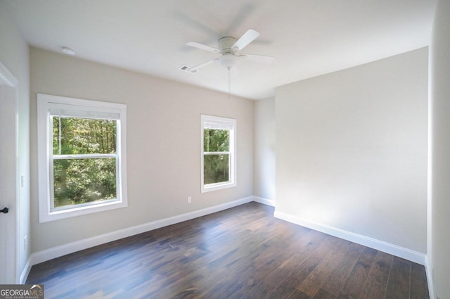 unfurnished room with ceiling fan, dark wood-type flooring, and plenty of natural light