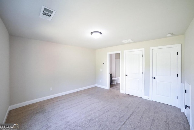 unfurnished bedroom featuring carpet and ensuite bath