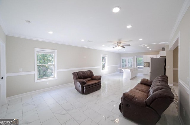 living room featuring ornamental molding, ceiling fan, and plenty of natural light