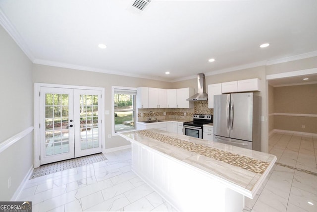 kitchen featuring wall chimney exhaust hood, white cabinetry, stainless steel appliances, and french doors