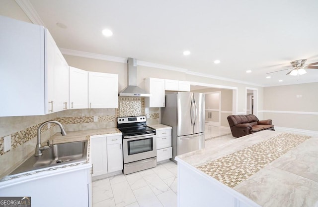 kitchen featuring sink, wall chimney range hood, white cabinetry, appliances with stainless steel finishes, and crown molding