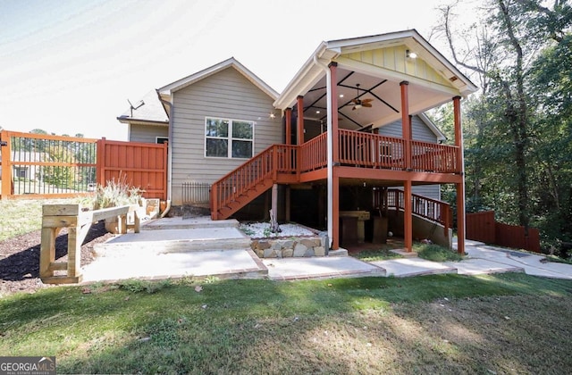 rear view of house with a lawn, a deck, ceiling fan, and a patio area