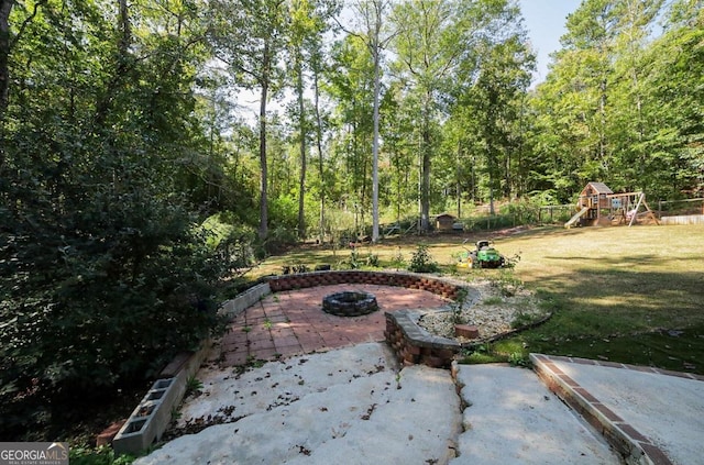 view of patio / terrace featuring a playground and an outdoor fire pit