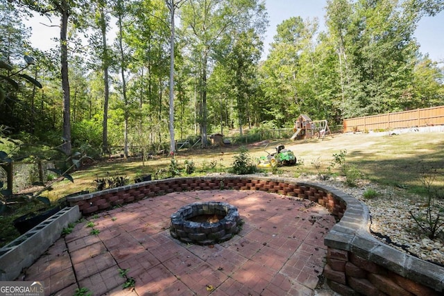 view of patio featuring a playground and a fire pit