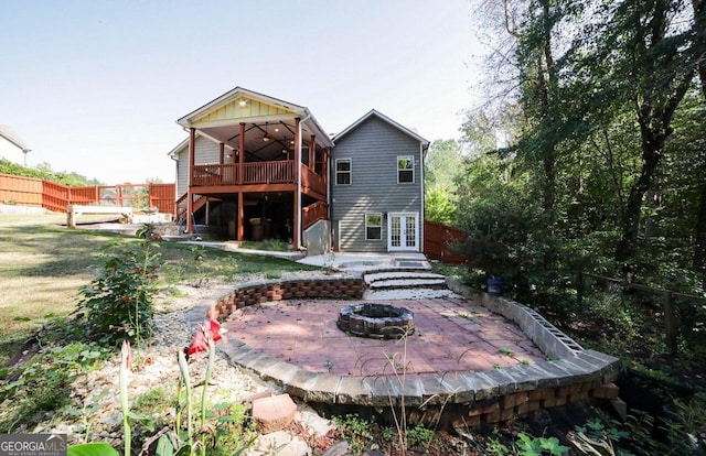 back of house featuring a deck, an outdoor fire pit, and a patio area