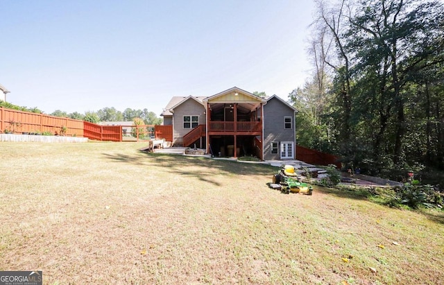 back of house with a deck and a yard