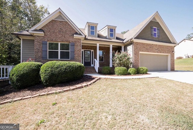 view of front of house with a front yard, a garage, and a porch