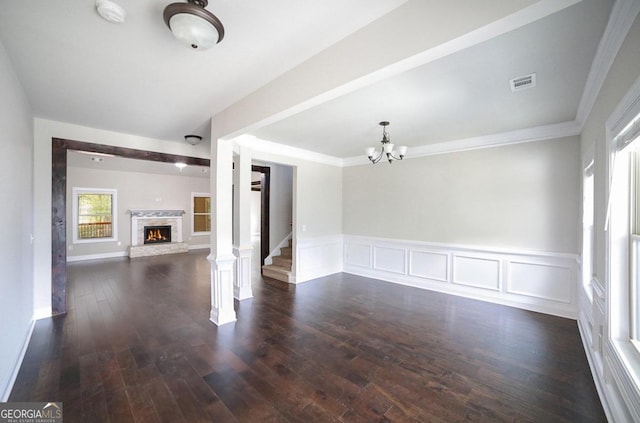 spare room featuring a chandelier, dark hardwood / wood-style floors, and crown molding