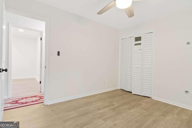 unfurnished bedroom featuring light hardwood / wood-style floors, ceiling fan, and a closet