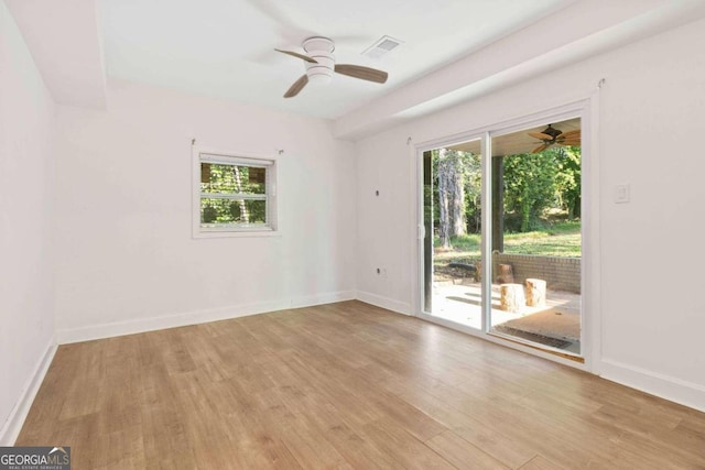 empty room with light wood-type flooring, ceiling fan, and a wealth of natural light