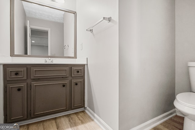 bathroom featuring hardwood / wood-style flooring, vanity, and toilet