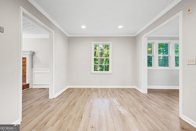 empty room with ornamental molding and light hardwood / wood-style flooring