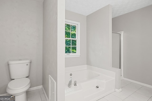 bathroom featuring tile patterned floors, shower with separate bathtub, toilet, and a textured ceiling