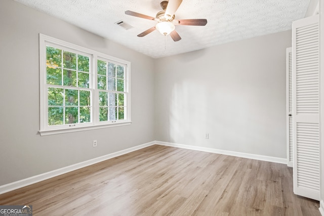 unfurnished bedroom featuring a textured ceiling, ceiling fan, a closet, and light hardwood / wood-style flooring