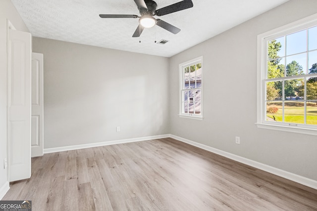 empty room featuring light hardwood / wood-style flooring, a textured ceiling, and ceiling fan