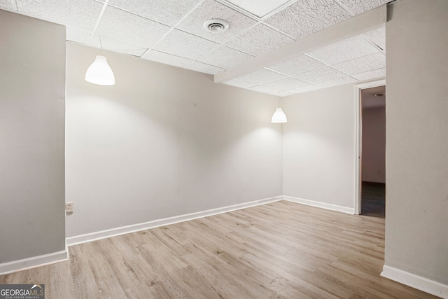 spare room with hardwood / wood-style flooring and a paneled ceiling