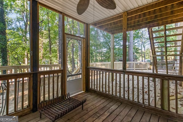 sunroom with ceiling fan and wooden ceiling