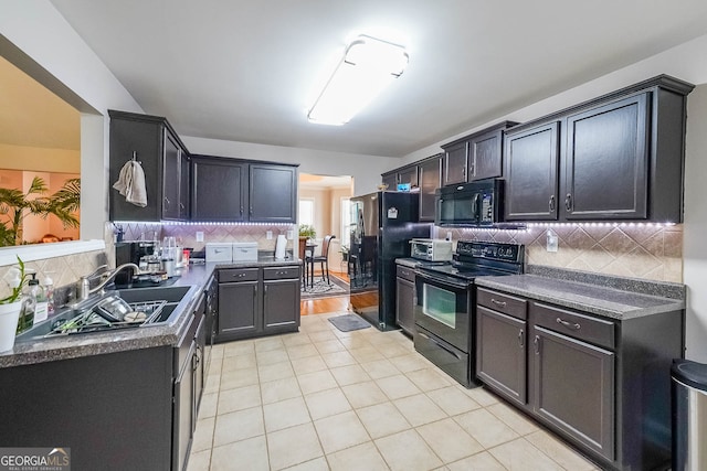 kitchen featuring backsplash, black appliances, sink, and light tile patterned floors