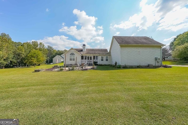 rear view of house featuring a lawn