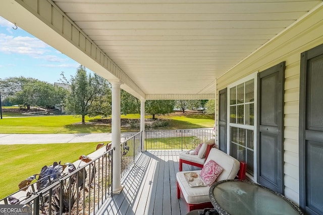 wooden terrace featuring a lawn