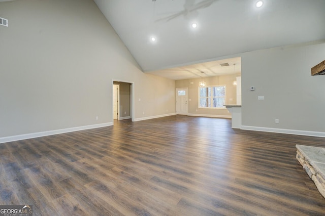 unfurnished living room featuring dark hardwood / wood-style flooring, high vaulted ceiling, and an inviting chandelier