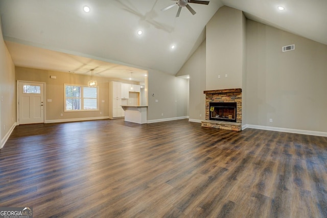 unfurnished living room featuring a fireplace, dark hardwood / wood-style flooring, high vaulted ceiling, and ceiling fan