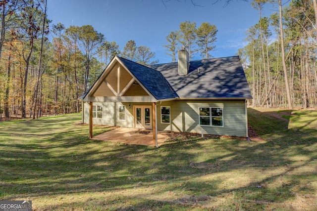 rear view of house with a yard and a patio