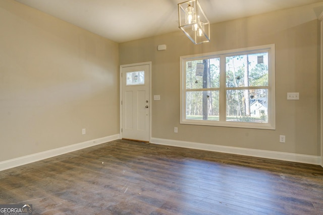 entrance foyer with dark hardwood / wood-style floors and an inviting chandelier