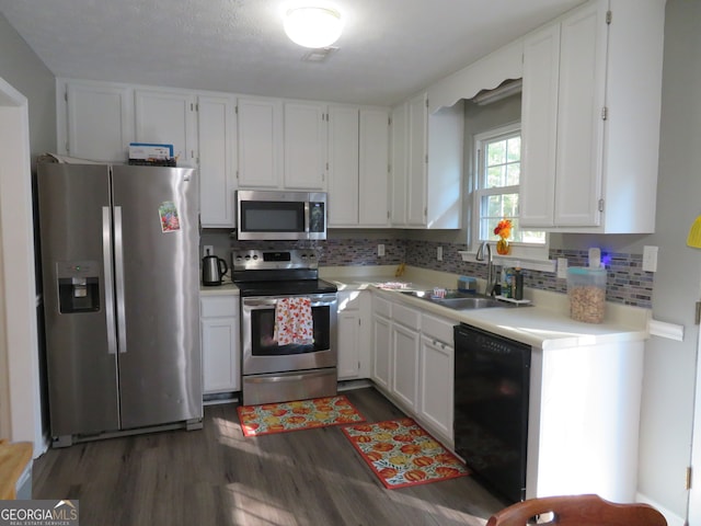 kitchen featuring appliances with stainless steel finishes, backsplash, sink, and white cabinetry