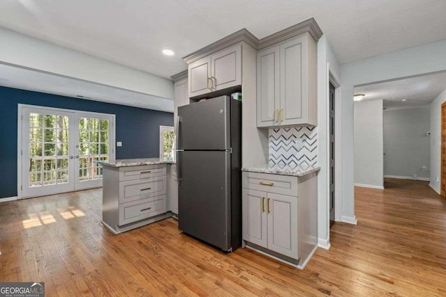 kitchen featuring gray cabinets, light hardwood / wood-style flooring, and stainless steel fridge