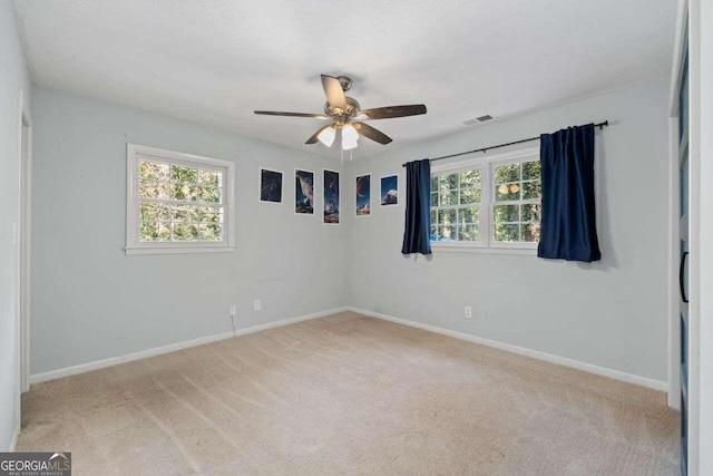 empty room featuring ceiling fan and light colored carpet